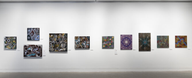 Art gallery wall with ten abstract paintings featuring intricate patterns and vibrant colors. The mood is creative and contemplative, under soft lighting.