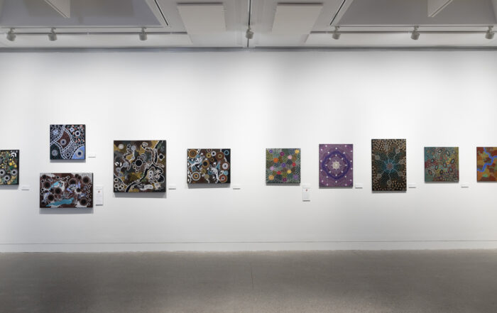 Art gallery wall with ten abstract paintings featuring intricate patterns and vibrant colors. The mood is creative and contemplative, under soft lighting.