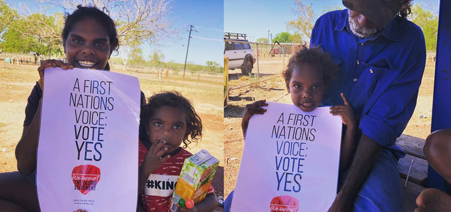 Two images of Indigenous Australian individuals holding a "Vote Yes" poster. They are outdoors with clear skies and dry landscape, conveying a hopeful message.