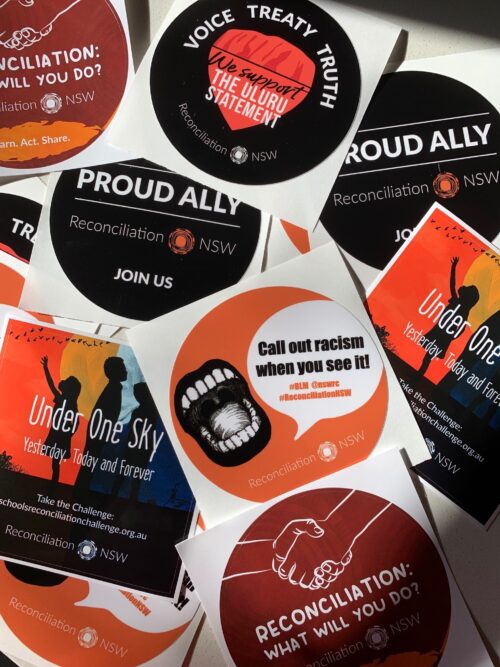 A mix of stickers promoting reconciliation in NSW. Messages include "Call out racism," "Proud Ally," and "Voice Treaty Truth," emphasizing unity and action.