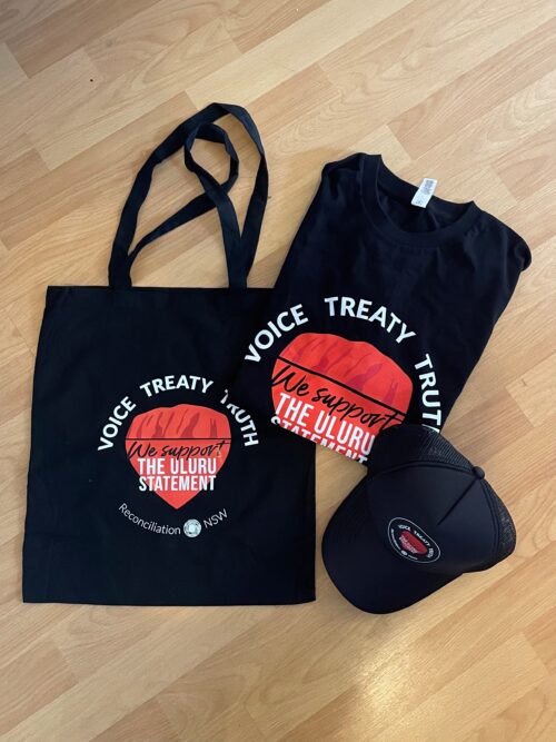 Black tote, t-shirt, and cap with "We support the Uluru Statement" text, featuring a red design. Logo includes "Voice Treaty Truth" and "Reconciliation NSW."